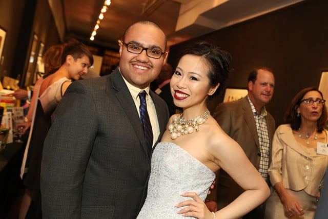 A man and woman posing with an animal at an event