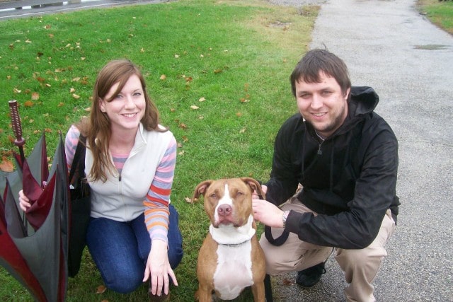 A man and woman posing with a tindog.