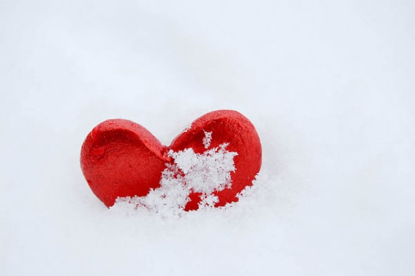 A red heart-shaped object nestled in the snow.