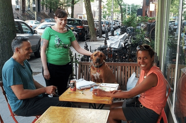 Three people sitting at an outdoor table at Bar Bruno.