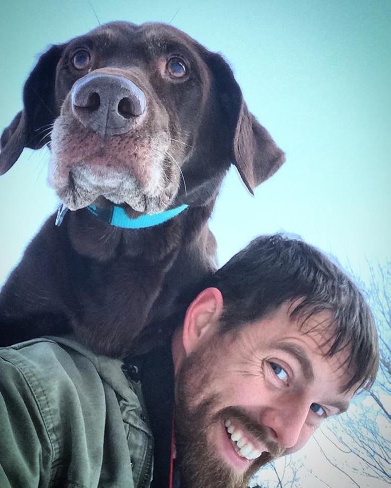 A terminally ill dog perches on the shoulder of a man during their heartfelt farewell journey.