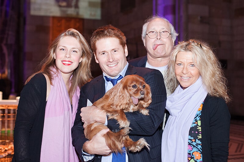 Toast Meets World, a famous canine Instagram celebrity, is seen posing for a photo with a group of people.