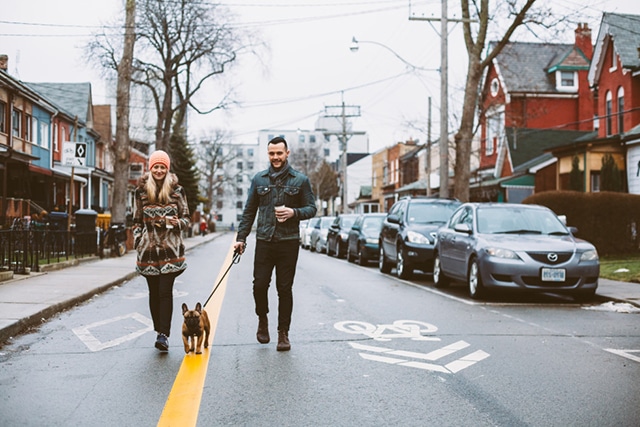 A couple walking their dog together in Toronto, strengthening their relationship while enjoying a leisurely stroll.