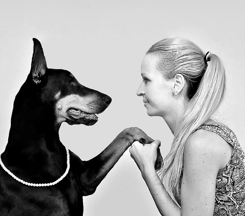 A black and white photo featuring a woman and a Doberman, showcasing the sincere bond between them.