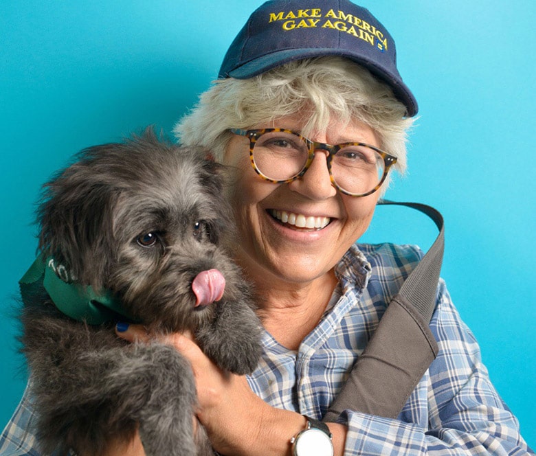 A woman wearing a hat and holding a dog, possibly in a No-Kill City.