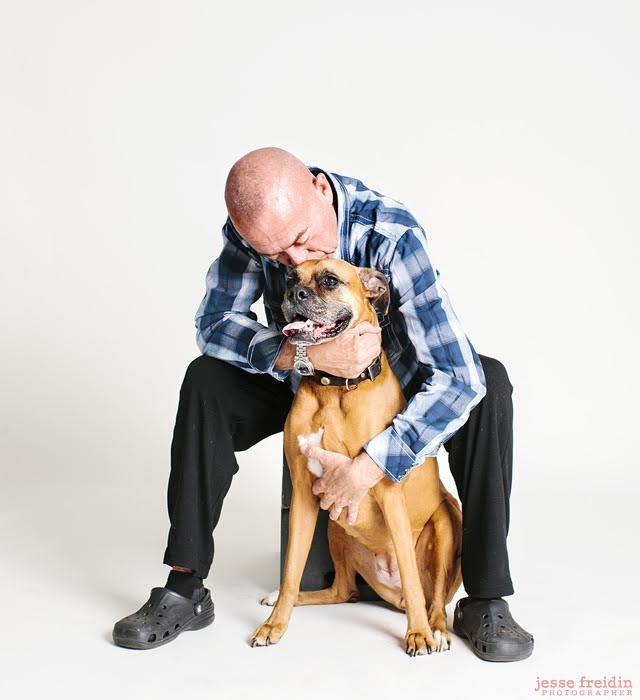 Jesse Freidin, a professional photographer, capturing the beautiful bond between a man and his boxer dog in a studio setting.