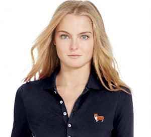 In celebration of National Dog Day, a woman dons a Ralph Lauren navy polo shirt featuring an adorable corgi embroidery.