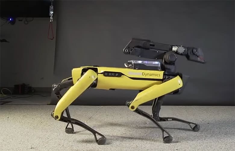 A yellow robot dog is busting a move in a room.