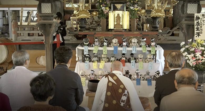 A group of dog robots sitting in front of a shrine.