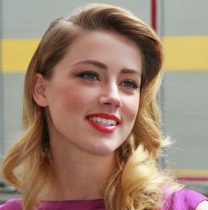 Amber Heard, a woman wearing a purple dress and red lipstick.