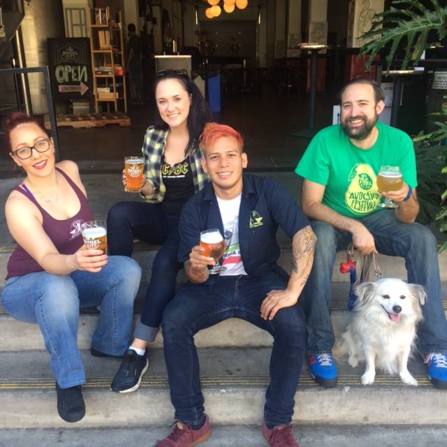 Four people and a dog posing for a photo at Angel City Brewery.