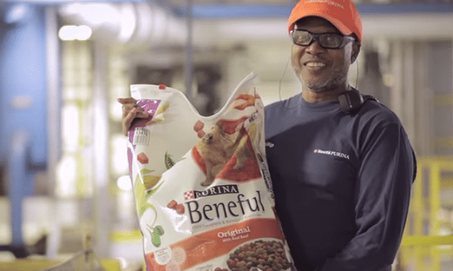 A man holding a bag of Beneful dog food.