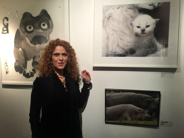 A woman with curly hair standing in front of pictures of animals at the BARC shelter.