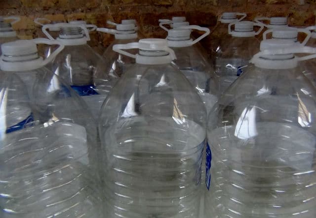 Many bottles of water are lined up in a room, creating an intriguing sight to keep your dog busy.