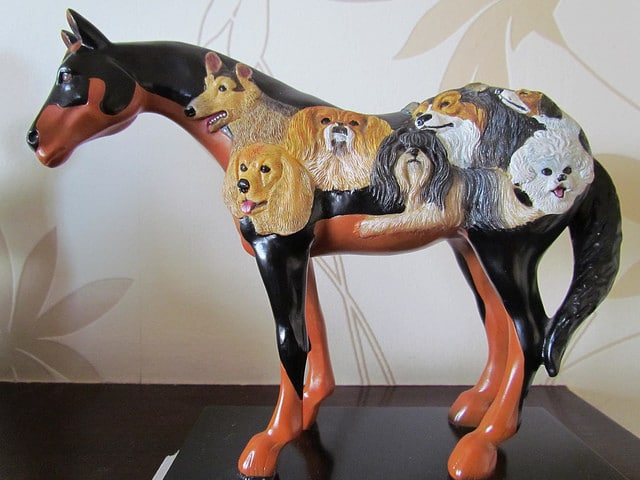 A statue of a horse adorned with dogs painted on it, beautifully capturing beloved dog sayings.