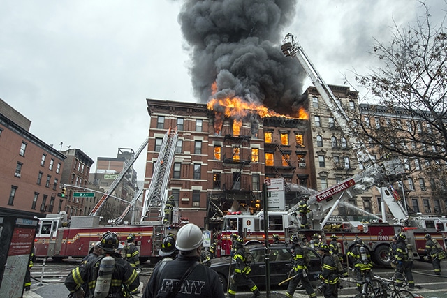 Firefighters work to extinguish a fire and assist with the aftermath of an explosion at a building in the East Village neighborhood of New York City.