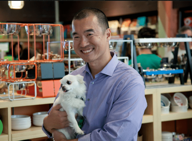 A man holding a dog in a Healthy Spot store.