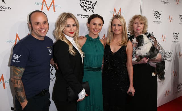 A group of people posing for a photo at the To the Rescue! 2015 New York Gala on a red carpet.