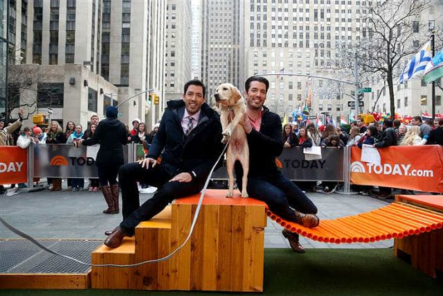 Two men, known as the Property Brothers, sitting on a wooden platform with TODAY.