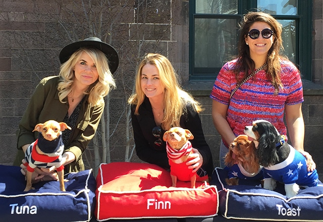 Three women posing for a photo with their beloved dogs, Tuna and Melts.