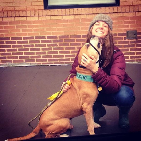 A woman crouching down next to a brown dog, acting as Rescuzilla.