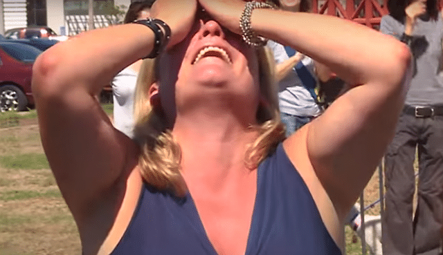 A woman at West Coast Animal Rescue is covering her face with her hands.