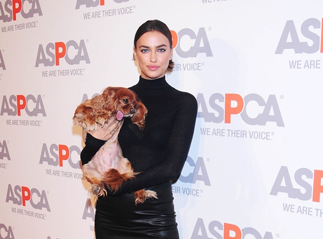 A woman holding a dog at a Young Friends Benefit event.