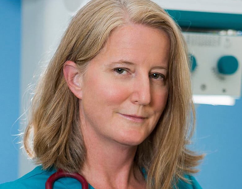 A woman in a blue shirt with a stethoscope specializing in holistic veterinarian practices and dog nutrition.