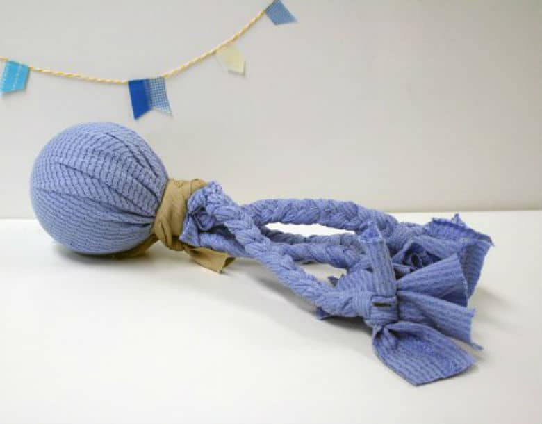 A blue knitted dog toy ball on a white table.