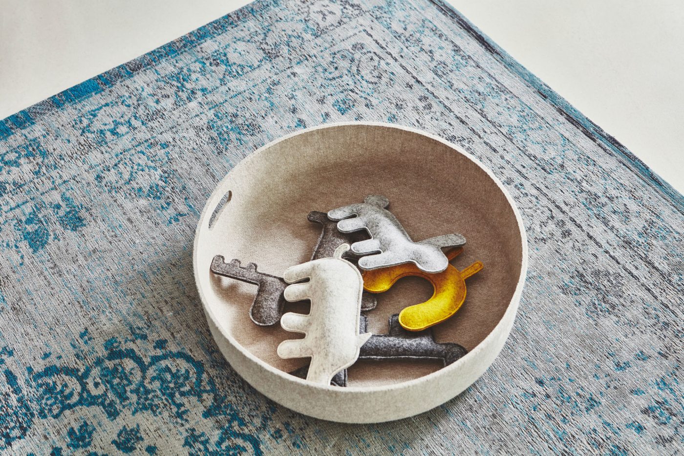 A must-have bowl of keys on a rug.