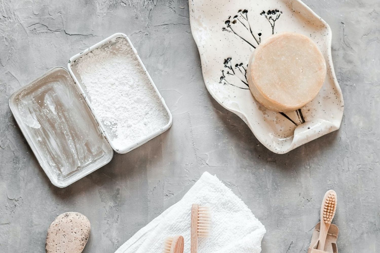 A set of brushes, soap, hand sanitizers, and other items on a concrete surface.