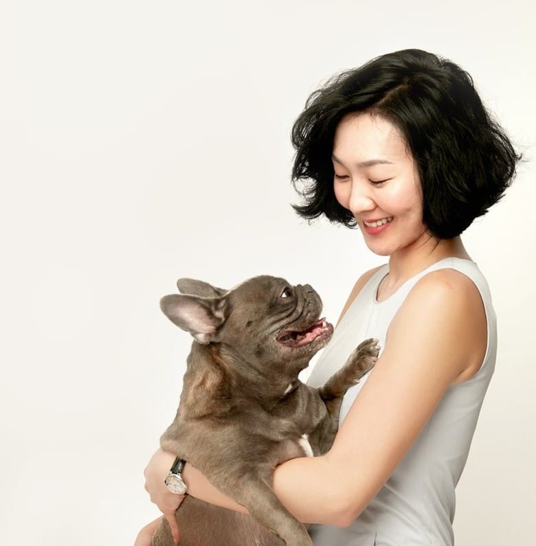 A woman holding a support dog.