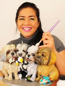 A woman is holding a cake with several figurines of dogs.