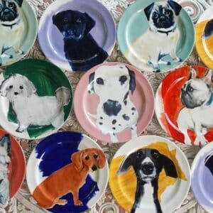 A set of colorful plates with dogs painted on them, showcasing the esteemed Dog Art World.