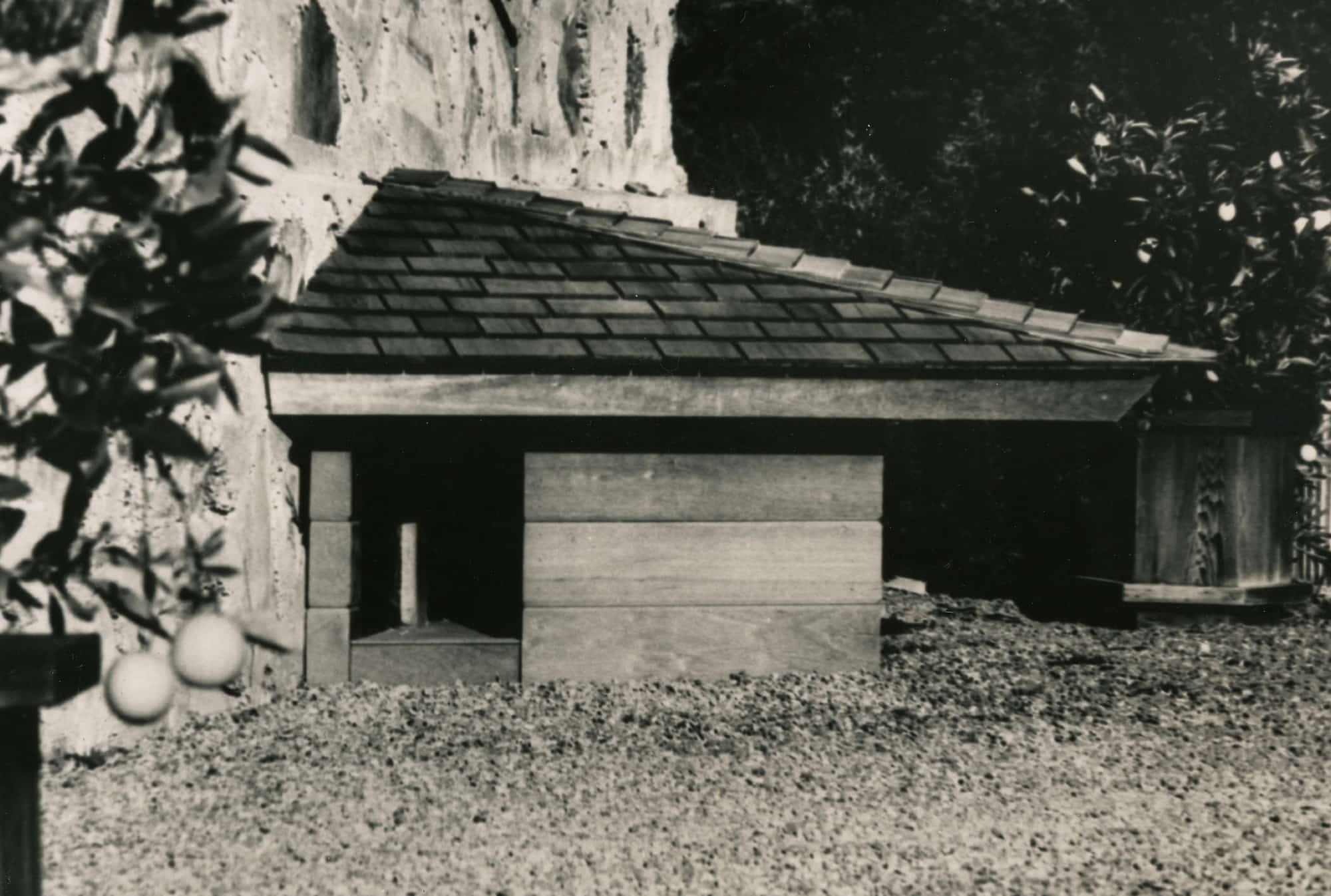 A black and white photo of a charming dog house.