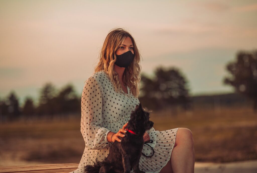 woman with mask on and dog outside