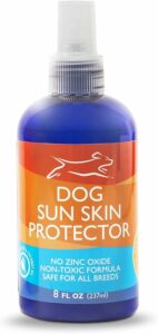 A blue 8 fl oz bottle of Dog Sun Skin Protector with a label indicating it contains no zinc oxide, has a non-toxic formula, and is safe for all breeds. For optimal dog safety this July 4th, consider using this gentle protector to keep your furry friend comfortable and sunburn-free.